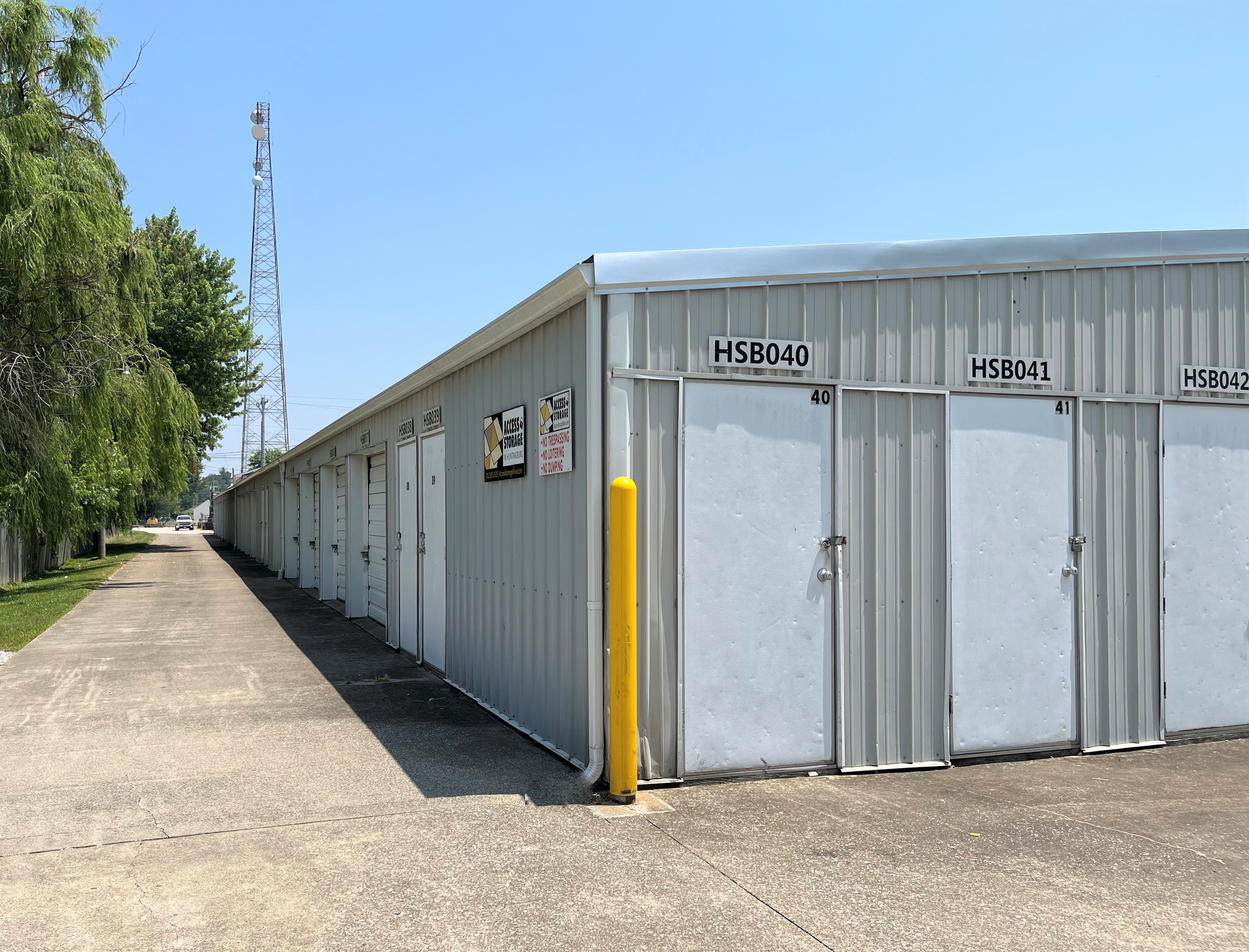 Paved driveways leading to white-door drive-up storage units, offering secure space in Huntingburg, IN.